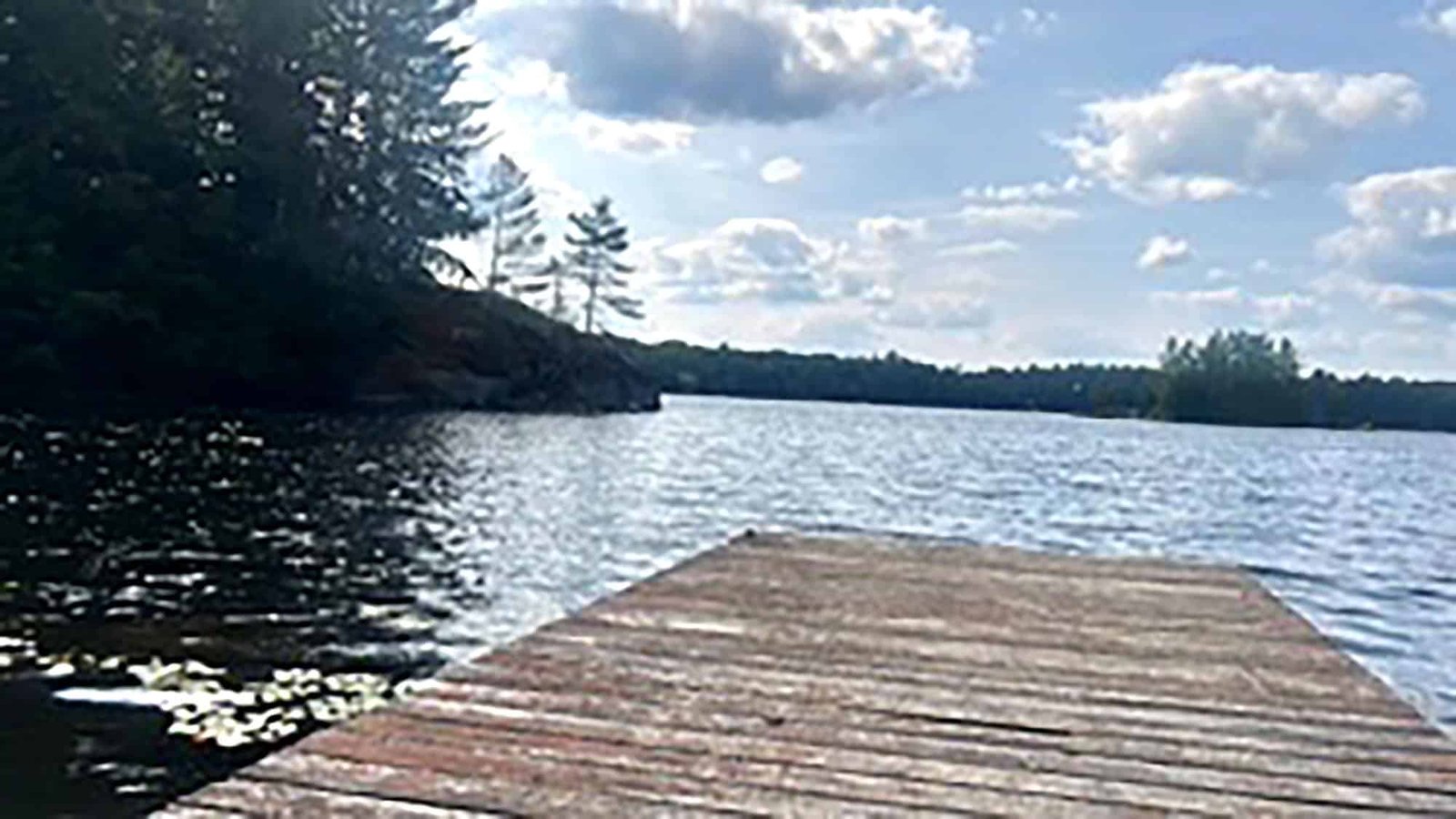 Rustic wooden dock extending into a Stormy Lake under a cloudy sky